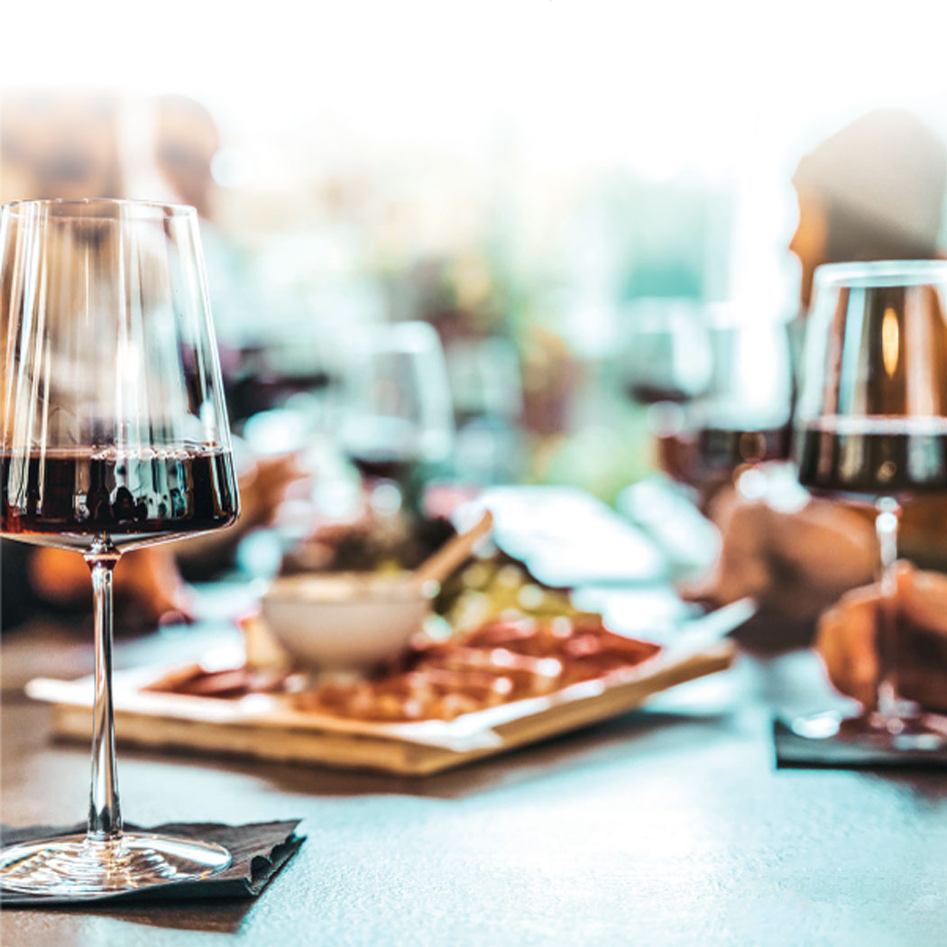 Theatermenü: Tapas und zwei Gläser mit Rotwein auf einem gedeckten Tisch